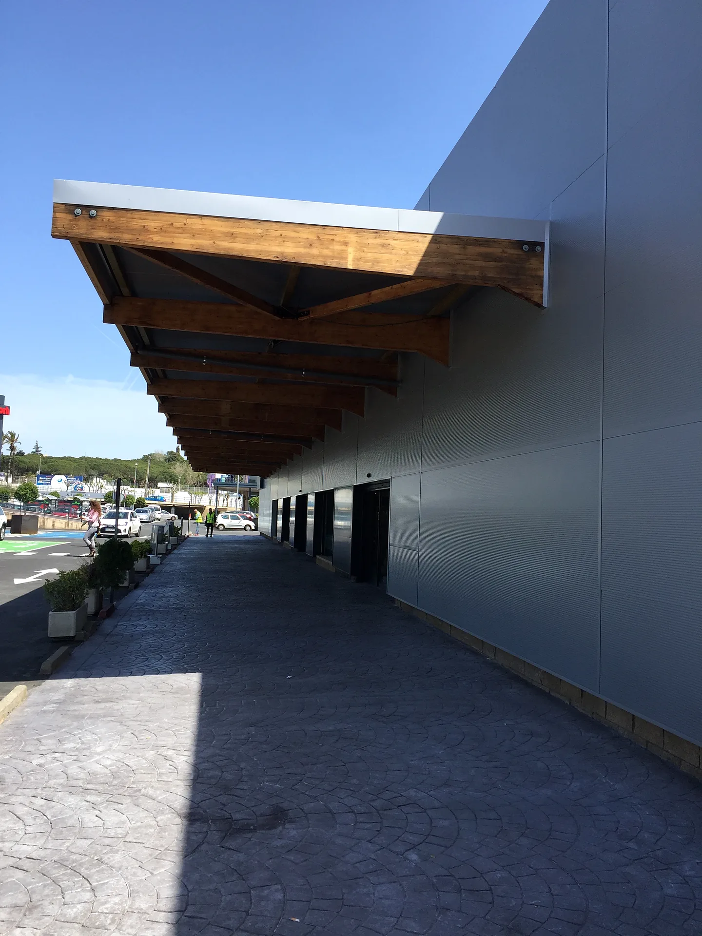 Pérgola de madera en la fachada del supermercado